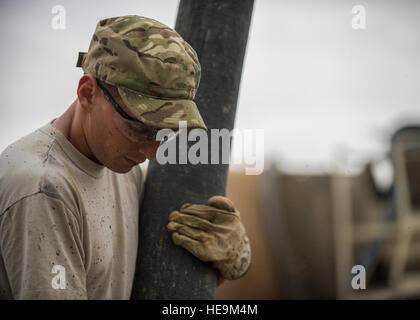 Senior Airman Giacobbe Nevills, 455th Expeditionary ingegnere civile Squadron sporco ragazzo, detiene un flessibile per dirigere il flusso di calcestruzzo per costruire i piè di pagina a Bagram Airfield, Afghanistan, 03 maggio 2016. Membri della 455th ECES stanno scavando fuori otto trincee per casa otto piè di pagina per il futuro posizionamento di quattro edifici riposizionabili. Senior Airman Justyn M. Freeman) Foto Stock