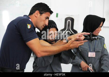 Un Carabinieri mostra una femmina di Polizia nazionale afgana assumere come obiettivo un AMD-65, una versione ungherese di AK-47, durante 8 settimane di polizia di base corso di formazione presso la centrale di Training Center a Kabul. Il Presidente afgano Hamid Karzai ha incaricato un ulteriore 5.000 donne essere aggiunto all'ANP entro il 2014; essi sono necessari per rispettare norme culturali fornendo allo stesso tempo la sicurezza. Il personale Sgt. Sarah Brown Foto Stock