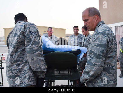 Lt. Col. Chris Hull, diritto, comandante di volo del 379 Expeditionary Medical Group enroute di stadiazione del paziente Facility, guida il suo team medico durante il caricamento di un paziente stretchered in una ambulanza per evacuazione Luglio 18, 2016 at Al Udeid Air Base, in Qatar. La squadra ha preparato 14 pazienti, compresi un militare di cane da lavoro, per essere trasportati su un C-17 Globemaster III volo per gli Stati Uniti le strutture militari in Germania. Sgt tecnico. Carlos J. Treviño) Foto Stock