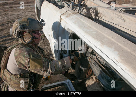 Un pararescueman dall'ottantatreesimo Expeditionary squadrone di salvataggio rimuove la parte di un sedile di un veicolo per liberare un manichino simulante un incidente durante un esercizio extrication a Bagram Air Field, Afghanistan, 23 gennaio, 2016. L'esercizio ha consentito ai membri del servizio dall'ottantatreesimo ERQS e il giunto di Craig Theatre qui in ospedale un opportunità per mettere in pratica la loro risposta a reali situazioni di emergenza. Tech. Sgt. Robert Cloys) Foto Stock