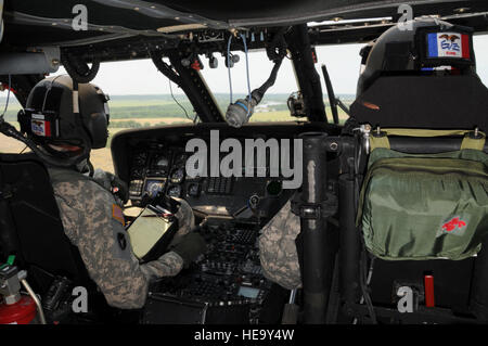 Lotta contro le inondazioni da aria Iowa esercito Guardia Nazionale piloti, Chief Warrant Officer 2 (CW2) Bryon Capouch e capitano (CPT) Ciad Promes, Charlie Azienda 2a dell'aviazione 147th battaglione, Boone Iowa; il pilota di un UH-60 Blackhawk elicottero vicino a South Sioux City, South Dakota. L'Iowa Guard i piloti sono per lo spostamento di grandi sacchi di sabbia per le aree lungo il Dakota del Sud / Iowa di confine interessate da inizio giugno le acque di esondazione del fiume Missouri. Il USAF Photo MSgt Vincent De Groot 185th Air Refuelling Wing Iowa Air National Guard (rilasciato) Foto Stock