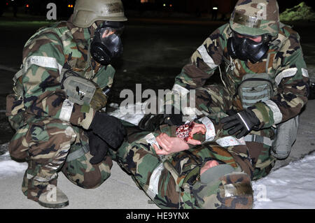 Airman 1. Classe Marco Velardebanuelos e Senior Airman Nicholas Peters, 51st ingegnere civile Squadron l'eliminazione degli ordigni esplosivi membri, rispondere a una vittima durante una massa di simulazione di incidenti di Febbraio 13, 2013 per la prontezza operativa esercizio Beverly Bulldog 13-02 a Osan Air Base, Repubblica di Corea. Esercizi come BB 13-02 consentono la base per operare in accresciuta stati di disponibilità per preparare un imminente ispezione in aprile e il mondo reale le contingenze. Senior Airman Kristina Overton) Foto Stock