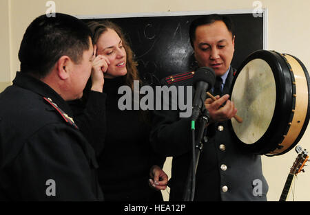 Stati Uniti Air Force Tech. Sgt. Julia Brundage insegna il tenente del Kirghizistan Col. Kubamych Tezekov come giocare al bodhran dopo aver eseguito per docenti e studenti dell'Accademia di polizia a Bishkek, Kirghizistan, gen. 28. Brundage è un cantante e multi-player strumento per gli Stati Uniti Forze Aeree centrale degli affari pubblici banda "Celtic Aire.' Senior Airman Nichelle Anderson/rilasciato) Foto Stock