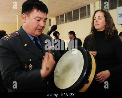 Stati Uniti Air Force Tech. Sgt. Julia Brundage insegna Col. La Almaz Bazarbaev come giocare al bodhran dopo aver eseguito per docenti e studenti dell'Accademia di polizia a Bishkek, Kirghizistan, gen. 28. Brundage è un cantante e multi-player strumento per gli Stati Uniti Forze Aeree centrale degli affari pubblici banda "Celtic Aire.' Senior Airman Nichelle Anderson/rilasciato) Foto Stock