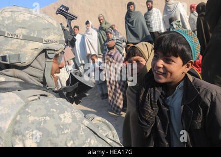 Stati Uniti Army Spc. Sydaless Watson, un soldato di alimentazione con la 97th Polizia Militare Battaglione di stanza a Fort Riley, Kan., nativo di Killeen, Texas, condivide una risata con un ragazzo afghano in Rajan Qala Village di Arghandab River Valley. Essi stavano aiutando polizia nazionale afgana, degli Stati Uniti e del Canada e le forze con funzionamento Fazilat, Gen10. Foto Stock