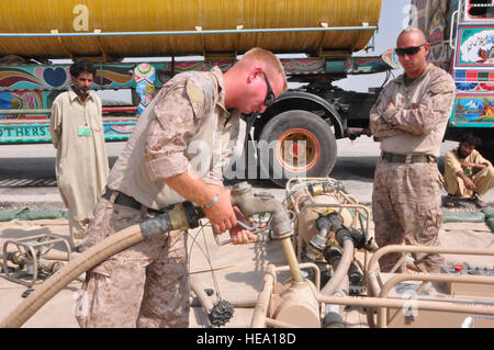 Stati Uniti Marine Corps Cpl. Kevin Trammell, Marine a rotore inclinabile 266 Squadrone rinforzato con VMM (-266-REIN), 26 Marine Expeditionary combustibili unità NCO in carica, lavora nella fossa del carburante come Sgt. Kenny Wilhite, combustibili di NCO del personale in carica, osserva ott. 23 sul flightline a Pano Aqil Cantonment, Pakistan. Poiché U.S. elicottero di soccorso ha iniziato il Agosto 5, più di dodici milioni di libbre di cibo sono stati trasportati in zone isolate che necessitano di assistenza dopo allagamento sinistra a circa 1/5 della contea sotto acqua a sua altezza. Contribuendo a quella che era la fuelers, assicurando gli elicotteri sono stati alimentati e re Foto Stock