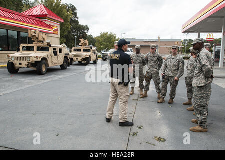 Cittadino soldati del 178mo di polizia militare in base alla società di Monroe riceve una breve dal sergente Max Nowinsky, West Chatham Precinct, Savannah-Chatham Metropolitan Police prima di iniziare la loro sorveglianza. La MPs pattugliano le strade per tutta la notte per dissuadere i saccheggi e per aiutare gli automobilisti a filamento. Foto Stock