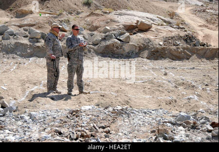 Da sinistra a destra, Bill Anderson, un ingegnere tecnico con l'esercito degli Stati Uniti ha Corpo degli Ingegneri, E DEGLI STATI UNITI Navy Lt. La Cmdr. Mike Cernuska, il filo entrante engineer per Ghazni Provincial Reconstruction Team, stand tra le linee di gesso ott. 14 che mostra il piano di progettazione per la nuova scuola in costruzione nel villaggio di Patoo nel distretto di Jaghori. La scuola sarà per 200 ragazzi e ragazze, e un campo di calcio è parte della proposta. Anderson è da Atlanta, Ga. e Cernuska è da Mt. Piacevole, Pa. U.S. Air Force 1 Lt. Katherine Roling, Ghazni Provincial Reconstruction Team Affari pubblici) Foto Stock