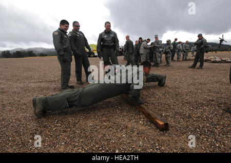 Stati Uniti Air Force aviatori guardare un push-up concorso dopo evacuazione medica formazione a Fort Hunter Liggett, California, 17 maggio 2011, durante il Global Medic 2011 e guerriero 91 11-01. Global Medic è un campo comune di esercitazione per il teatro di medicina aeronautica sistema di evacuazione e la massa medical componenti progettati per replicare tutti gli aspetti della lotta contro il servizio medico di supporto. Senior Airman Raymond A. Estes Foto Stock