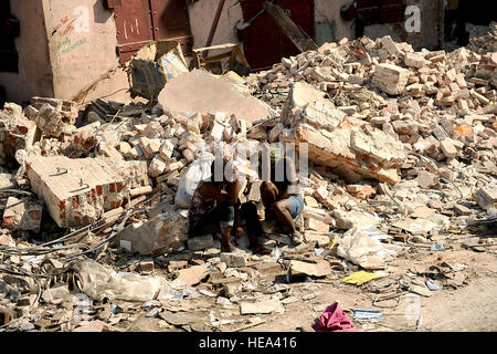 Donne haitiani sedersi sulle macerie di un edificio crollato a Port-au-Prince, Haiti, 20 gennaio 2010. Negli Stati Uniti e a livello internazionale le unità militari e civili di agenzie di aiuto stanno svolgendo missioni umanitarie e di soccorso in caso di catastrofe operazioni come parte dell'operazione Unified risposta dopo un 7.0-grandezza terremoto ha causato gravi danni vicino a Port-au-Prince Gen 12, 2010. Master Sgt. Jeremy Lock, U.S. Air Force Foto Stock