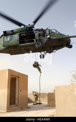 US Air Force (USAF) Pararescuemen assegnato all'101st salvataggio Expeditionary Squadron (ERQS), respingere da un bilico USAF HH-60G Pave Hawk elicottero, durante le operazioni di ricerca e salvataggio (SAR) formazione condotta a Baghdad International Airport, Iraq, durante l'Operazione Iraqi Freedom. Foto Stock