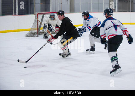 Stati Uniti Air Force Senior Airman Hayden McAleavey pattini con il puck durante la pratica per i comandanti' Cup hockey gioco presso la pista di pattinaggio su ghiaccio su Fort Wainwright, Alaska, nov. 18, 2014. Questo anno il Gioco verrà giocato al centro Carlson a Fairbanks e segna il ventesimo anniversario della serie che box Eielson aviatori contro soldati da interno Alaska basi dell'esercito. Tech. Sgt. Giuseppe Swafford Foto Stock