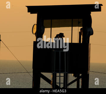 GUANTANAMO Bay a Cuba - Spc. Emely Nieves dal Porto Rico Esercito Nazionale guardie di guardia del suo posto al di sopra della Joint Task Force di detenzione di Guantanamo facility di sunrise, Gen 7. JTF Guantanamo fornisce un sicuro, umano, legale e trasparente di cura e custodia dei detenuti, compresi quelli condannati dalla commissione militare e quelli ordinati rilasciato da un tribunale. La JTF conduce la raccolta di intelligence, analisi e diffusione per la tutela dei detenuti e il personale che lavora in JTF Guantanamo strutture e a sostegno della guerra al terrore. JTF Guantanamo fornisce il supporto per l'Ufficio di militari Foto Stock