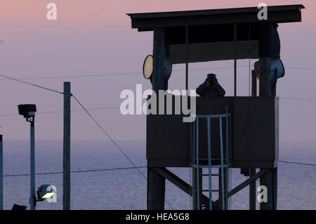 GUANTANAMO Bay a Cuba - Spc. Emely Nieves dal Porto Rico Esercito Nazionale guardie di guardia del suo posto al di sopra della Joint Task Force di detenzione di Guantanamo facility di sunrise, Gen 7. JTF Guantanamo fornisce un sicuro, umano, legale e trasparente di cura e custodia dei detenuti, compresi quelli condannati dalla commissione militare e quelli ordinati rilasciato da un tribunale. La JTF conduce la raccolta di intelligence, analisi e diffusione per la tutela dei detenuti e il personale che lavora in JTF Guantanamo strutture e a sostegno della guerra al terrore. JTF Guantanamo fornisce il supporto per l'Ufficio di militari Foto Stock