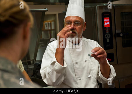 BASE COMUNE ELMENDORF-Richardson, Alaska -- Università di Anchorage in Alaska lo Chef Giovanni Layton insegna aviatori dal 673d Medical Support Squadron circa utilizzando una scala e dosare gli ingredienti nella sala da pranzo JBER facility cucina 23 agosto 2012. Layton è un professore a contratto di arti culinarie a SAU che è di insegnare il personale della sala da pranzo JBER facility. (U.S. Air Force Photo/ Airman 1. Classe Omari Bernard) Foto Stock