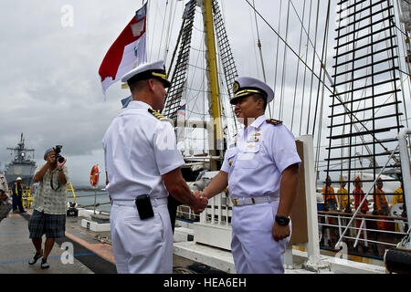 Stati Uniti Navy Capt. Jeffrey James, da sinistra, Base comune perla Harbor-Hickam commander, saluta marina indonesiana della Cmdr. Haris Bima della Marina Indonesiana Tall Ship, KRI Dewaruci a base comune Harbor-Hickam perla, Hawaii. La KRI Dewaruci, arrivati a JBPHH il 29 febbraio 2012, per una breve visita di porta mentre durante il tragitto gli Stati Uniti continentali. Dewaruci ha cominciato la sua crociera da Surabaya, East Java, Indonesia, a gennaio 14. Come parte dell'operazione internazionale di vela (OpSail) 2012 per commemorare il bicentenario della guerra del 1812. Foto Stock