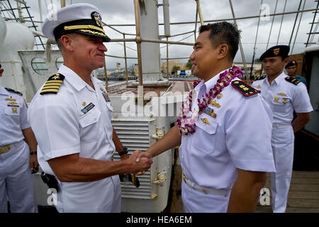 Stati Uniti Navy Capt. Jeffrey James, da sinistra, Base comune perla Harbor-Hickam commander, dà una moneta a marina indonesiana della Cmdr. Haris Bima della marina indonesiana Tall Ship, KRI Dewaruci a base comune Harbor-Hickam perla, Hawaii. La KRI Dewaruci, arrivati a JBPHH il 29 febbraio 2012, per una breve visita di porta mentre durante il tragitto gli Stati Uniti continentali. Dewaruci ha cominciato la sua crociera da Surabaya, East Java, Indonesia, 14 genn., come parte dell'operazione internazionale di vela (OpSail) 2012 per commemorare il bicentenario della guerra del 1812. ( U.S. Air Force Tech. Sgt. Michael R. Holzworth Foto Stock