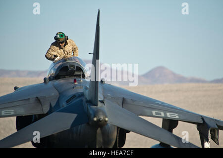 Stati Uniti Lancia Marine Cpl. Philip Pettey, un sedile meccanico assegnato al Marine squadrone di attacco 214 "pecore nere", Marine Corps Air Station Yuma, Ariz., pulisce la tettoia su un AV-8B Harrier durante la formazione integrata esercizio 2-15 al Marine Corps Air il combattimento a terra (Centro MCAGCC) ventinove Palms, California, 18 febbraio, 2015. MCAGCC conduce pertinenti live-fuoco combinato di formazione di armi, le operazioni in ambiente urbano e giunto/coalizione di integrazione a livello di formazione che promuovono le forze operative readiness. Tech. Sgt. Efren Lopez Foto Stock