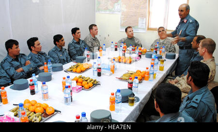 Supporto regionale Command-South Commander, Col. Greg Baine, attende mentre interprete Sabour Raouf ascolta la polizia nazionale afgana di Formazione Regionale Comandante Center-Kandahar, Briga. Gen. Nasrullah Zarifi (in piedi), parla ai suoi poliziotti circa l'American Corano che brucia a una polizia Training Center, 5 aprile 2011, a livello FOB Walton, provincia di Kandahar, Afghanistan. Tech. Sgt. Adrienne Brammer) Foto Stock