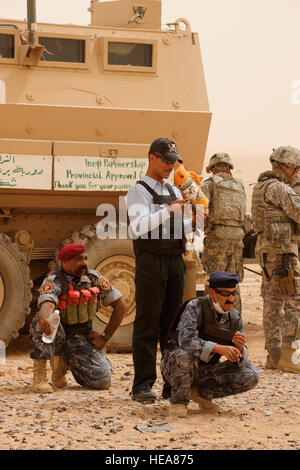 Poliziotti iracheni da Tikrit Al Sequor stazione di polizia attendere prima di familiarizzazione con le armi della formazione, insegnata da U.S. I soldati della XXV truppe speciali battaglione di distacco di sicurezza, XXV divisione di fanteria, sul poligono di tiro alla contingenza Base Operativa Speicher, nel nord Iraq, 15 luglio. Foto Stock