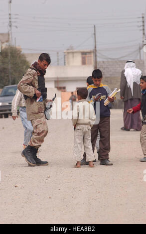 Un esercito iracheno soldato parla ai bambini del posto su una pattuglia con U.S. Esercito Società Delta, 2° Battaglione, 7° reggimento di cavalleria, quarta brigata Team di combattimento, 1° Divisione di cavalleria, da Fort Bliss, Texas, nel quartiere palestinese di Mosul, Iraq, 19 marzo. Senior Airman Vanessa Valentino) Foto Stock