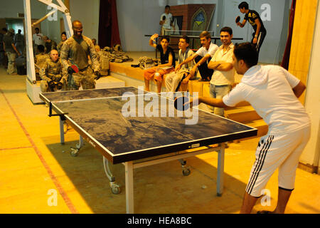 Stati Uniti Air Force Senior Airman Terrance Hanley, da Upper Marlboro, Md., una fotocamera di combattimento videografo da Hill Air Force Base in Utah, gioca a ping pong con un ragazzo iracheno durante una visita al Mujamma Centro Giovanile per la valutazione del sito e per mano di forniture scolastiche per i bambini del Mujamma, Iraq, 9 luglio. Foto Stock