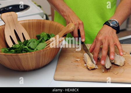 Stati Uniti Air Force 2 Lt. Samantha Morrison, 4° Fighter Wing Public Affairs vice capo, prepara il pollo e gli spinaci per un post-allenamento pasto presso la sua casa in Goldsboro, N.C., Ottobre 2, 2013. Morrison mantiene una dieta alimentare naturale in preparazione per la IRONMAN World Championship in Kailua-Kona, Hawaii, Ottobre 12, 2013. Sta cercando di migliorare il suo terzo posto finale in evento del 2012. Airman 1. Classe Giovanni Nieves Camacho) Foto Stock