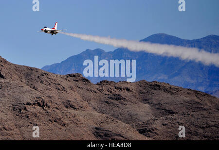 Un U.S. Air Force Thunderbird rende un assolo di passare in un display della F-16 Fighting Falcon di velivoli funzionalità durante Indian Springs apprezzamento giorno 11 marzo 2014, a Creech Air Force Base, Nev. Il team di precisione esegue manovre aeree per esporre le funzionalità della moderna ad alte prestazioni di aerei di spettatori in tutto il mondo. Airman 1. Classe C.C. Foto Stock