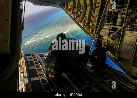 Giappone Aria forza di autodifesa Master Sgt. Toyonaga Toshihisa, sinistra e Tech. Sgt. Takahashi Tetsuki, entrambi 1st Tactical Airlift Wing loadmasters, guardare oltre la zona di atterraggio sulla remota isola micronesiana di Falalap dal retro di un C-130 Hercules 8 dicembre 2015, durante il funzionamento il Natale Drop. Il 2015 Natale missioni di caduta di segnare il primo tempo l'evento include aria trilaterale supporto da JASDF e Royal Australian Air Force. Il personale Sgt. Alexander Riedel) Foto Stock