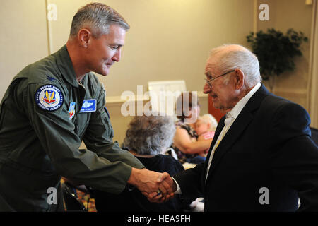 Stati Uniti Air Force Col. John Pearse, Air Combat Command direttore del personale, saluta pensionati U.S. Il personale dell'esercito Sgt. Daniel Fenton durante il POW/MIA Pranzo al Langley Air Force Base, Va., Sett. 20, 2013. Fenton, un veterano della Corea, è stato catturato il 25 aprile 1951 ed è stata mantenuta per oltre due anni. Senior Airman Brittany Paerschke-O'Brien Foto Stock