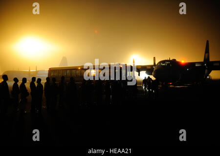 Membri della massa giapponese Forza di Autodifesa (JGSDF) stand in linea in attesa di salire a bordo di una giapponese C-130 Hercules aeromobili cargo ad Homestead Air Base riserva Fla., 23 gennaio, 2010. Questi servizio JGSDF fanno parte di un medico del team di supporto che consentirà di feriti i superstiti del terremoto di Haiti. Il personale Sgt. Greg C. Biondo Foto Stock