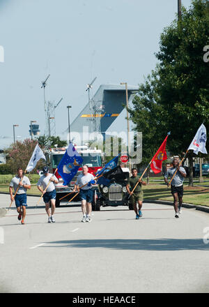 I membri di ciascun ramo militare di correre con i loro rispettivi servizi di bandiere per la parata di base motivi per l'avvio del prigioniero di guerra/mancante in azione la cerimonia di ritiro, Sett. 21, 2012, a base comune Charleston - Air Base, S.C. Squadre provenienti da vari comuni unità di base ha organizzato una veglia in esecuzione alla base via, eseguendo il POW/mia bandiera intorno alla pista per 24 ore. Foto Stock