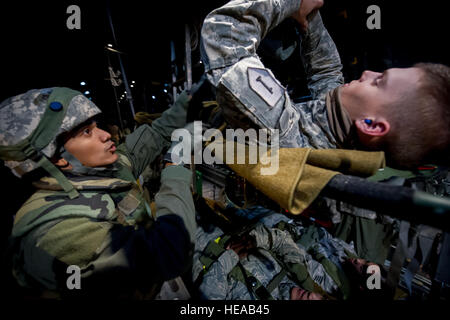 Stati Uniti Air Force Staff Sgt. Kenneth Benavides, xviii di medicina aeronautica squadrone di evacuazione (AES), Kadena Air Base, Okinawa, in Giappone, assicura una fascetta intorno U.S. Pfc dell'esercito. Bryan Ryder, fante, 1a divisione di fanteria, 2° Battaglione, 2° Reggimento di Fanteria, Ft. Knox, Ky., che hanno simulato un paziente a bordo di una C-130 Hercules aeromobile in Alessandria, La., 22 febbraio, 2013, a sostegno di Joint Readiness Training Center (JRTC) Istituto di medicina aeronautica esercitazione di evacuazione. I membri del servizio a JRTC 13-04 sono educati nel combattere la cura del paziente e Istituto di medicina aeronautica evacuazione in un combattimento simulato l'ambiente. Tech. Sgt. John R. Nimmo, Suor/ Foto Stock