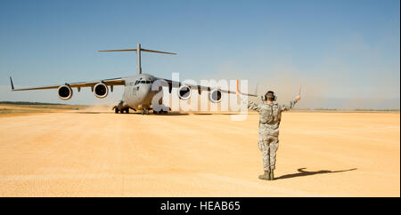 Stati Uniti Air Force Senior Airman Douglas, Prewitt 621st risposta di emergenza parafango, Base comuneGuire-Dix Mc-Lakehurst, N.J., esegue il marshalling di un C-17 Globemaster III di aerei di Geronimo zona di atterraggio durante un esercizio di campo in corrispondenza della giunzione Readiness Training Center (JRTC), Fort Polk, La., gen. 16, 2014. I membri del servizio a JRTC 14-03 sono educati nel combattere la cura del paziente e Istituto di medicina aeronautica evacuazione in un combattimento simulato l'ambiente. Tech. Sgt. Matthew Smith Foto Stock