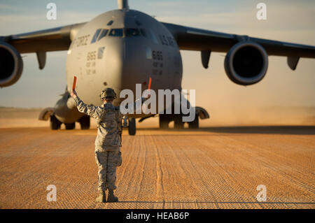 Stati Uniti Air Force Senior Airman Douglas, Prewitt 621st risposta di emergenza parafango, Base comuneGuire-Dix Mc-Lakehurst, N.J., esegue il marshalling di un C-17 Globemaster III di aerei di Geronimo zona di atterraggio durante un esercizio di campo in corrispondenza della giunzione Readiness Training Center (JRTC), Fort Polk, La., gen. 16, 2014. I membri del servizio a JRTC 14-03 sono educati nel combattere la cura del paziente e Istituto di medicina aeronautica evacuazione in un combattimento simulato l'ambiente. Tech. Sgt. Matthew Smith Foto Stock