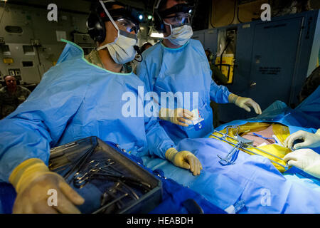 Da sinistra, tattiche di critical care team expeditionary - enhanced (TCCET-E) i membri del team, U.S. Air Force Master Sgt. Jose Arias-Patino, sala operatoria tecnico chirurgico, E DEGLI STATI UNITI Air Force Lt. Col. Gerald Fortuna, trauma chirurgo, sia con la 86Medical Group, Ramstein Air Base, Germania, eseguire la simulazione di una laparotomia esplorativa procedura chirurgica durante il volo a bordo di una C-17 Globemaster III a Joint Readiness Training Center (JRTC), Fort Polk, La., Gennaio 17, 2014. I membri del servizio a JRTC 14-03 sono educati nel combattere la cura del paziente e Istituto di medicina aeronautica evacuazione in un combattimento simulato ambiente Foto Stock