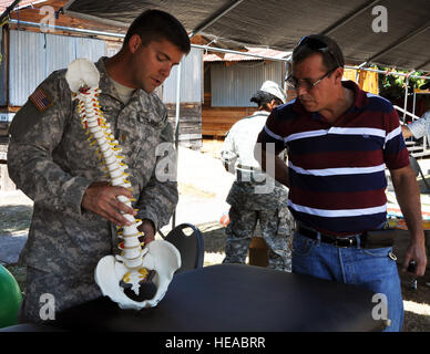 Stati Uniti Esercito il Mag. Joshua Brooks, la terapia fisica ufficiale responsabile per la Joint Task Force Bravo elemento medico (MEDEL), visite con Martin Chahin, un servizio estero dipendente nazionale, durante una fiera della salute a Soto Cano Air Base, Honduras, 27 febbraio 2014. Durante la fiera, organi di servizio nonché i dipendenti civili sulla base sono stati in grado di ricevere gratuitamente gli screening sanitari e una varietà di test medici e servizi. Il cap. Zach Anderson) Foto Stock