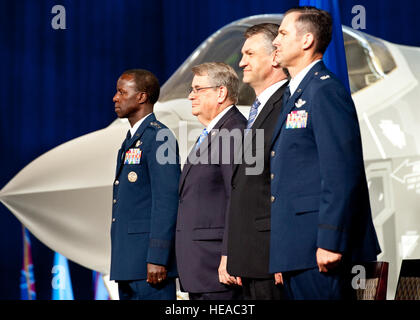 Gen. Edward riso, l'aria di istruzione e di formazione il comandante del Comando, sorge a Florida Sen. Don Gaetz, Larry Lawson, executive vice president e general manager del F-35 programma di Lockheed Martin e Col. Andrew Toth, la trentatreesima Fighter Wing Commander a conclusione dell'F-35 Lightning II joint strike fighter cerimonia di rollout, 26 agosto, a Eglin Air Force Base, Fla. Foto Stock