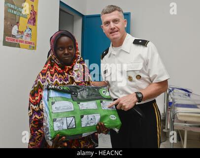 Stati Uniti Esercito Brig. Gen. Wayne Grigsby Jr., comandante della Combined Joint Task Force-Horn dell Africa, dà un locale una tenda insetticida durante un tour della Karta health clinic durante una cerimonia del taglio del nastro per la sua apertura ufficiale, Karta, Gennaio 30, 2014. Apertura del Karta Health Clinic darà al popolo di Karta un più facile accesso a una struttura medica. Senior Airman Tabatha Zarrella Foto Stock