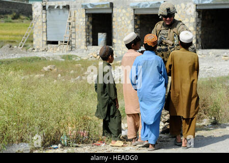 Provincia KHOWST, Afghanistan - STATI UNITI Army Spc. Anthony Parker, Provincial Reconstruction Team Khowst delle forze di sicurezza team gunner di Everett, Massachusetts, parla con locale ragazzi afghani durante una visita alla Jaji distretto di Maidan, Ott 4. Durante la visita il PRT ha eseguito un controllo finale sulla Jaji Maidan di alta scuola di computer lab che ha incluso l'installazione di 15 nuovi computer e riparazione di otto computer esistenti per l apprendimento della lingua inglese. Stati Uniti Air Force Senior Airman Sandra Welch, Khowst Provincial Reconstruction Team Affari pubblici) Foto Stock