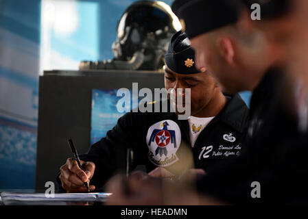 Stati Uniti Air Force Il Mag. Darrick Lee, Thunderbird 12, Public Affairs Officer, autografi una brochure durante un incontro e saluto sessione al Las Vegas Motor Speedway prima del fly-by per la NASCAR Kobalt Tools 400, 9 marzo 2014. Il personale Sgt. Larry E. Reid Jr., rilasciato) Foto Stock