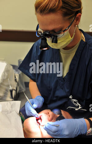 Il cap. ReAnn Cornell, 8 Operazione di medico dentista Squadron, esegue un esame dentale di un paziente qui Luglio 21. Un esame dentale è costituito da raggi x, cancro orale screening, igiene orale e una scansione per qualsiasi potenziale odontoiatriche. Foto Stock