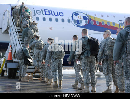 Membri della New York Army National Guard 27 della brigata di fanteria Team di combattimento a bordo di un aeromobile JetBlue al campo di Hancock di Siracusa, N.Y., Gennaio 31, 2012, iniziando il loro lungo viaggio in Kuwait. Le guardie e le donne potranno ricevere le loro missioni e i loro obiettivi una volta in Kuwait. Foto Stock