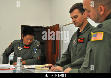 HICKAM AFB - Hickam AFB, Hawaii C-17 Globemaster III Membri di equipaggio: Royal Australian Air Force volo pilota tenente Samuel Gadsby (sinistra) 535th Airlift Squadron capitano Graham Boutz e xv Operations Squadron Capt. Andrew Stewart recensione piano di volo al loro ufficio presso Hickam AFB, Hawaii prima di partire per una missione a Noumea, Nuova Caledonia per trasportare i delfini dal U.S. La marina di mammiferi marini Programma su nov. 7, 2009. L'equipaggio ha preso i marinai, gli appaltatori e i delfini a Noumea in laguna di supporto MINEX 2009, che è un caso umanitario dove U. S. Marina, Francia, Australia e Nuova Zelanda de Foto Stock