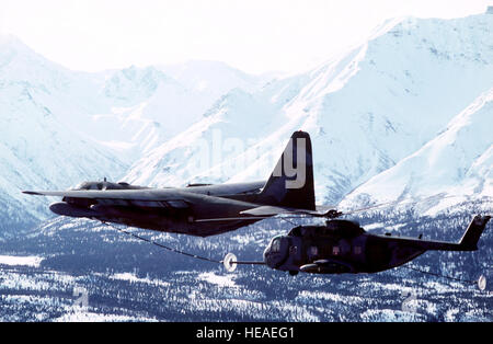 Un 210th Air Rescue Squadron (210th ARS), Air National Guard C-130 Hercules aeromobile conduce un in volo il rifornimento di carburante con un 71st Air Rescue Squadron (71st ARS) HH-3E Jolly gigante verde elicottero. Il 210th ARS assumerà le missioni di salvataggio quando la settantunesima ARS viene disattivato il 1 giugno 1991. Foto Stock