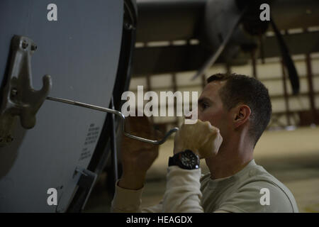 Stati Uniti Air Force Airman 1. Classe Scott Miller, un capo equipaggio assegnati alla 455th Expeditionary Manutenzione aeromobili squadrone, stringe un tampone di jack in posizione in modo che il suo team è in grado di sollevare un C-130J Super Hercules per manutenzione nov. 3, 2014 a Bagram Air Field, Afghanistan. Miller, nativo di La Quinta in California è distribuito dal xix Manutenzione aeromobili squadrone a Little Rock Air Force Base, Ark. Master Sgt. Cohen A. Giovani Foto Stock