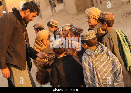 Una polizia nazionale afgana officer trattative per bambini afgani nel villaggio di Shabila Kalan, provincia di Zabul, Afghanistan, nov. 30, 2009. Il personale Sgt. Christine Jones) Foto Stock