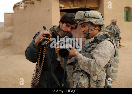 Stati Uniti Air Force Tech. Sgt. Efren Lopez, 4a lottare contro lo squadrone della fotocamera, mostra le fotografie digitali di un esercito nazionale afghano soldato nel villaggio di Shabila Kalan, provincia di Zabul, Afghanistan, nov. 30, 2009. Il personale Sgt. Christine Jones) Foto Stock