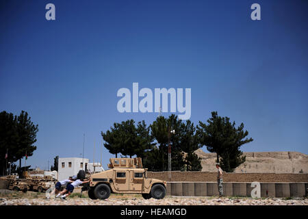 Avieri assegnato al Team di Ricostruzione Provinciale Zabul spingere un Humvee così una bottiglia legata al paraurti anteriore riceve entro una scatola con nastro adesivo sul cemento, in corrispondenza di una delle stazioni per il morale della squadra giorno, ''incredibile gara'', concorrenza, 29 maggio avanti operanti Base Smart, Afghanistan. La concorrenza che in primo piano 11 a quattro squadre di persona, featured riprese nitide, cavalcate, un Humvee push, un tappo di bottiglia match game, Cervello occhiolini, push-up e un sacco di cardio. Foto Stock