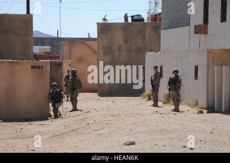 Afghan uniforme di polizia e militari dal 4 BCT fornire 360 gradi di sicurezza al di fuori di un composto in Artat Shar durante una riunione agricoli tra i responsabili provinciali e le forze della coalizione hanno come parte del Centro Nazionale di Allenamento rotazione 11-10, a Ft. Irwin, California, 18 settembre 2011. NTC è una delle ultime evoluzioni di formazione tecnica per le unità essendo certificata da distribuire alle loro zone di operazione. SSgt Austin Pritchard (rilasciato) Foto Stock